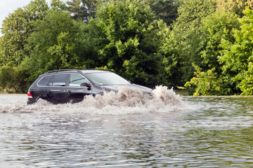 Car trying to drive against flood on the street in Gdansk, Poland