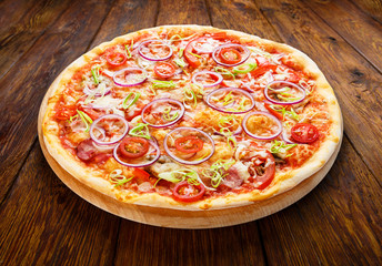 Delicious pizza with onions, bacon and cherry tomato