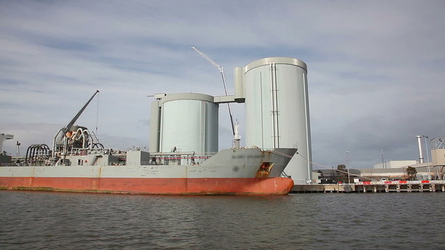 Sailing pass a cement carrier at a factory