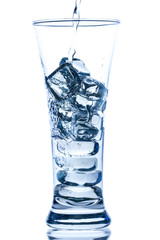 pouring water in an elegant tall glass with ice and water drops on white background