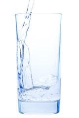 pouring water in an elegant glass and water drops on white background