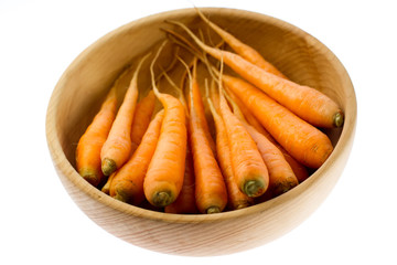 fresh carrots in wooden plate on white background. vegetarian food