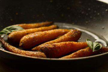 whole roasted carrots with spices in a skillet. Vegetarian healthy food