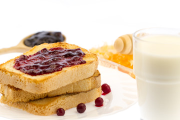 fresh french toast with honey and jam on a white plate with berries on a white background. healthy diet