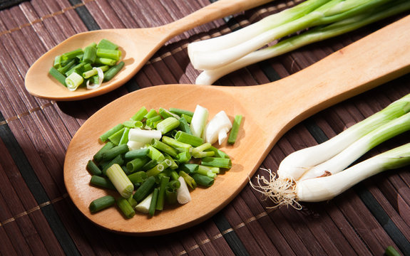 Chopped green  onions and spoon on a wooden