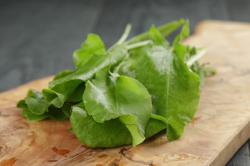 fresh sorrel leaves on cutting board on oak wood table