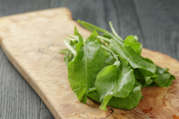 fresh sorrel leaves on cutting board on oak wood table
