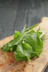 fresh sorrel leaves on cutting board on oak wood table