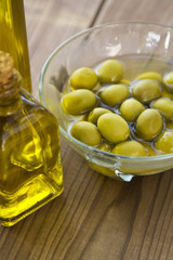 olives and olive oil on wooden background