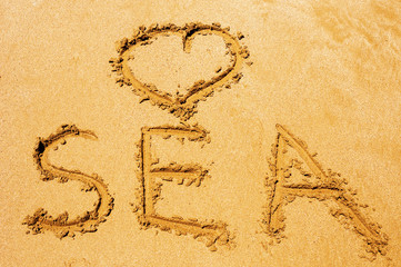 Sea written on sandy beach