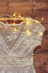 vintage white crochet lace top on hanger with garland lights
