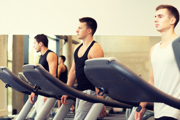 group of men exercising on treadmill in gym