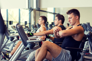 men working out on exercise bike in gym