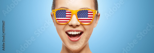 happy teenage girl in glasses with american flag