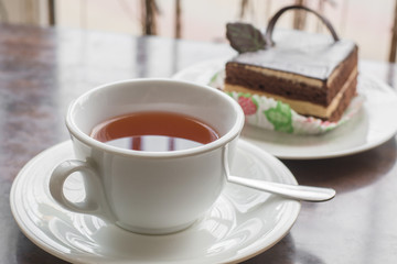 White cup of tea and cake in the cafe