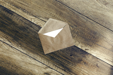 envelope.the envelope of brown paper with a blank white form on wooden background