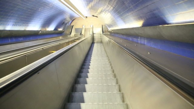 Escalator going down to enter subway station