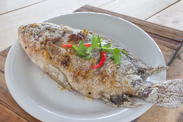 fish grilled with salt on wood background,Thai food