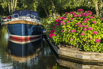 Yacht on the water. Pier near the house. Summer rest. Reflection in water. Summer еvening