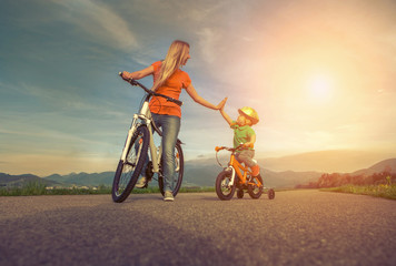 Fototapeta na wymiar Happiness Mother and son on the bicycles funning outdoor