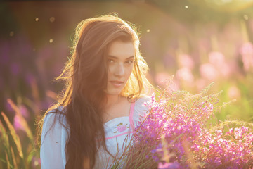 Beautiful young girl, happy, holding lavender, in a field on sun