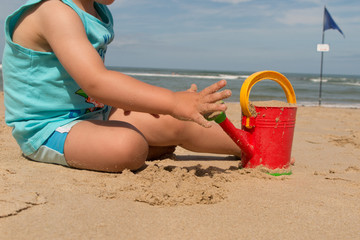 Cute baby boy playing with beach toys