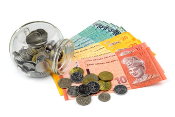 Saving concept. Banknotes and coins with a glass container isolated on white background.