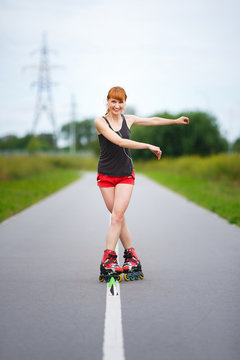 Attractive girl rollerblading on the road