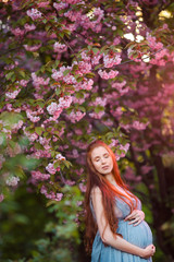 Pregnant caucasian woman takes rest outdoor