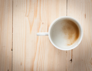 empty coffee cup on wood table, retro filter effect