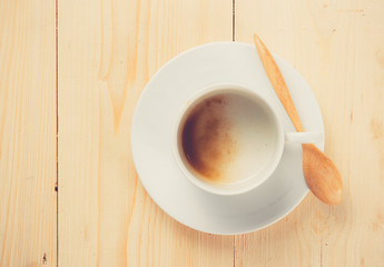 empty coffee cup on wood table, retro filter effect