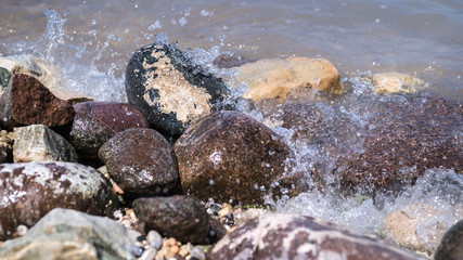 Colorful Rocks with splashing waves on a Beach