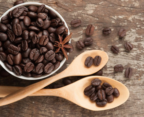 Coffee beans in cup on wood background,selective focus