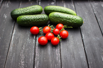 delicious fresh cucumbers and cherry tomatoes lie on a wooden table. Correct and healthy food
