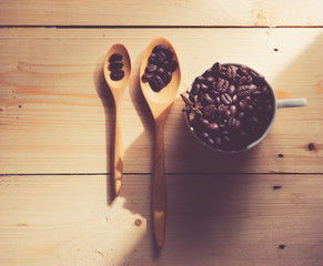 Coffee beans in cup on wood background,selective focus, retro fi