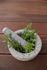 Healthy and fragrant herbs in a stone mortar