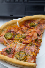 pieces pizza on laptop keyboard background