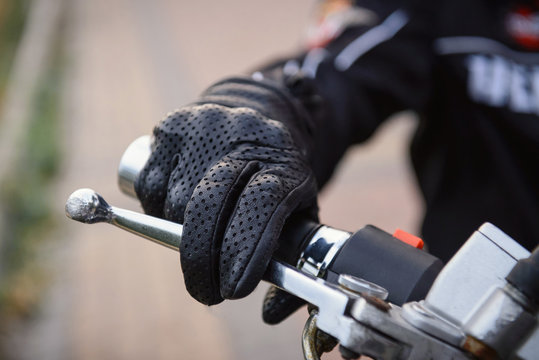 Fototapeta protective biker gloves on a motorcycle wheel