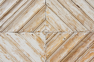 Rhomb pattern of the old weathered white-painted wooden gate.