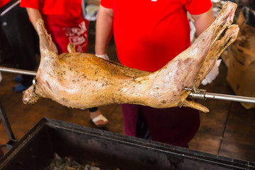 Two chefs cooking a spit roast