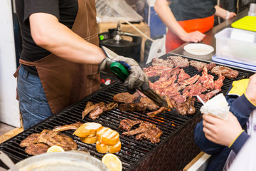 Man with Cooking Meat on Grill at Food Festival