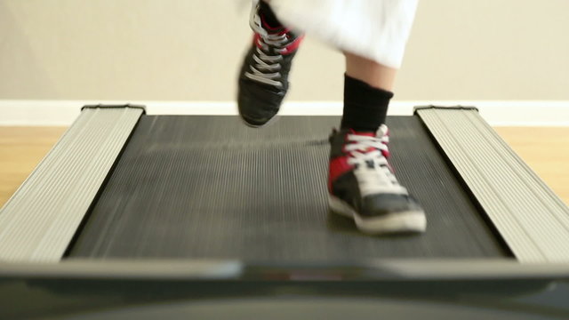 Boy running on the treadmill in the gym
