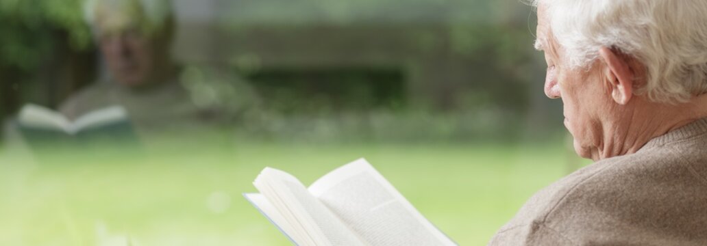 Thoughtful senior man reading book