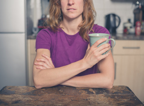Young woman with cup in kitchen