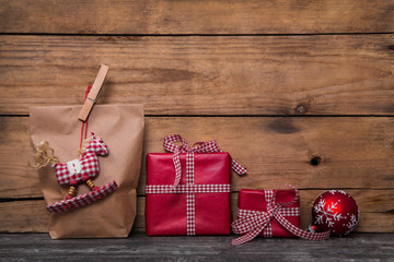 Weihnachtlich verpackte Geschenke und Pakete in rot mit Holz Hintergrund rustikal und kariertem...