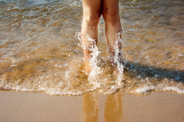 legs of little girl in sea wave
