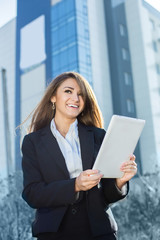 Fototapeta premium Successful businesswoman or entrepreneur using a digital tablet computer, standing in front of his office.