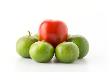 tomato and green lemons on white