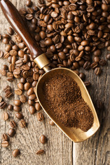 ground coffee in scoop and coffee beans on a wooden background, view from the top