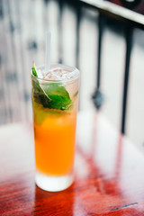 Orange cocktail with mint leaves outdoors